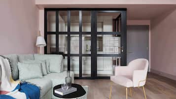 A modern living room with a sofa, a coffee table, a chair, and a large sliding glass door leading to a kitchen.