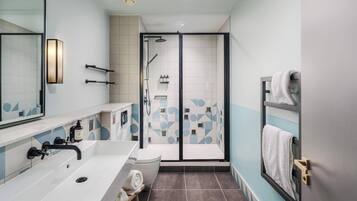 Un baño moderno con un lavamanos grande, inodoro y zona de ducha.