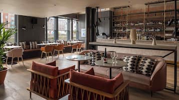 A modern bar area with seating, a bar counter, and a large window.