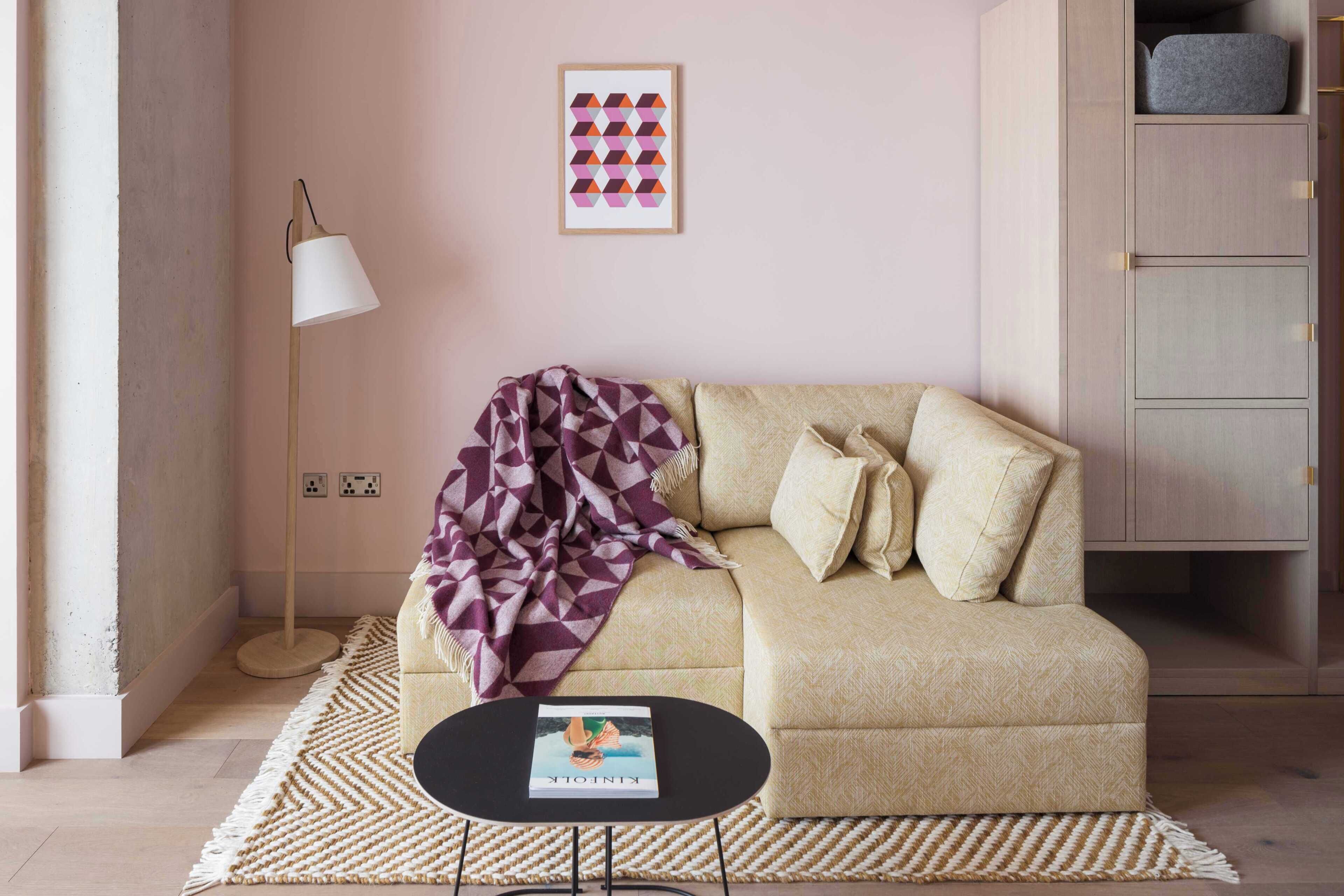 A living room with a sofa, a coffee table, a lamp, and a wall art piece.