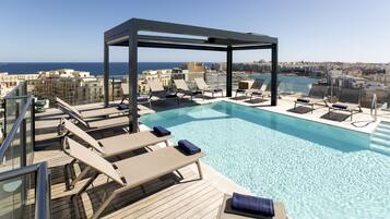 Piscine extérieure, parasols de plage, chaises longues
