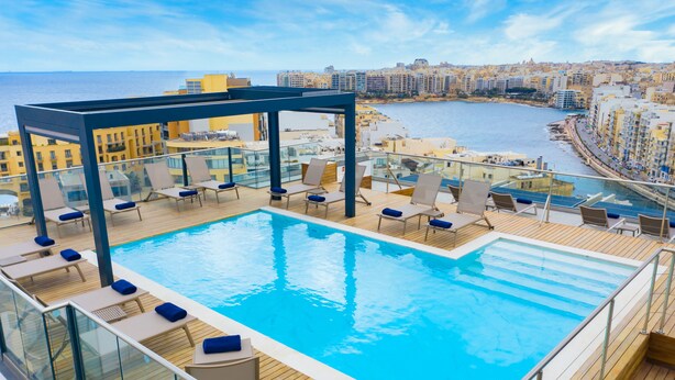 A rooftop infinity pool with lounge chairs and a glass balustrade overlooking a coastal cityscape. - Mercure St. Julian's Malta (St. Julian's)