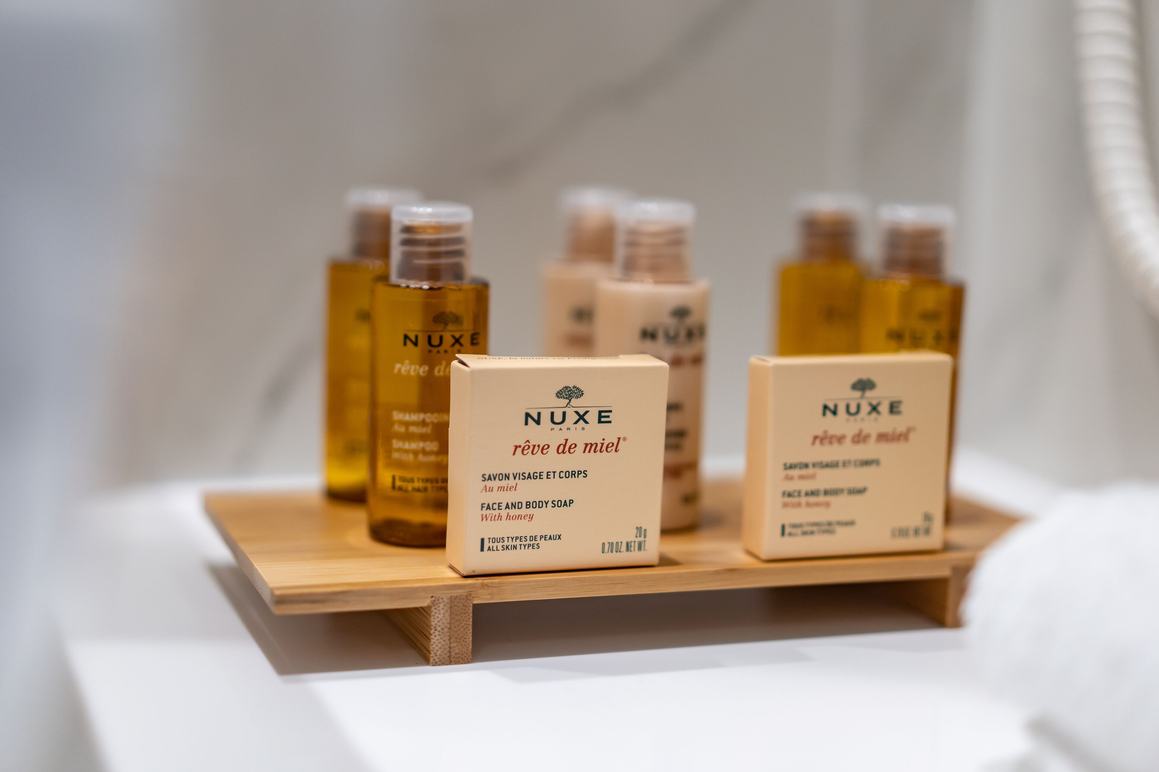 A display of Nuxe skincare products on a wooden shelf.