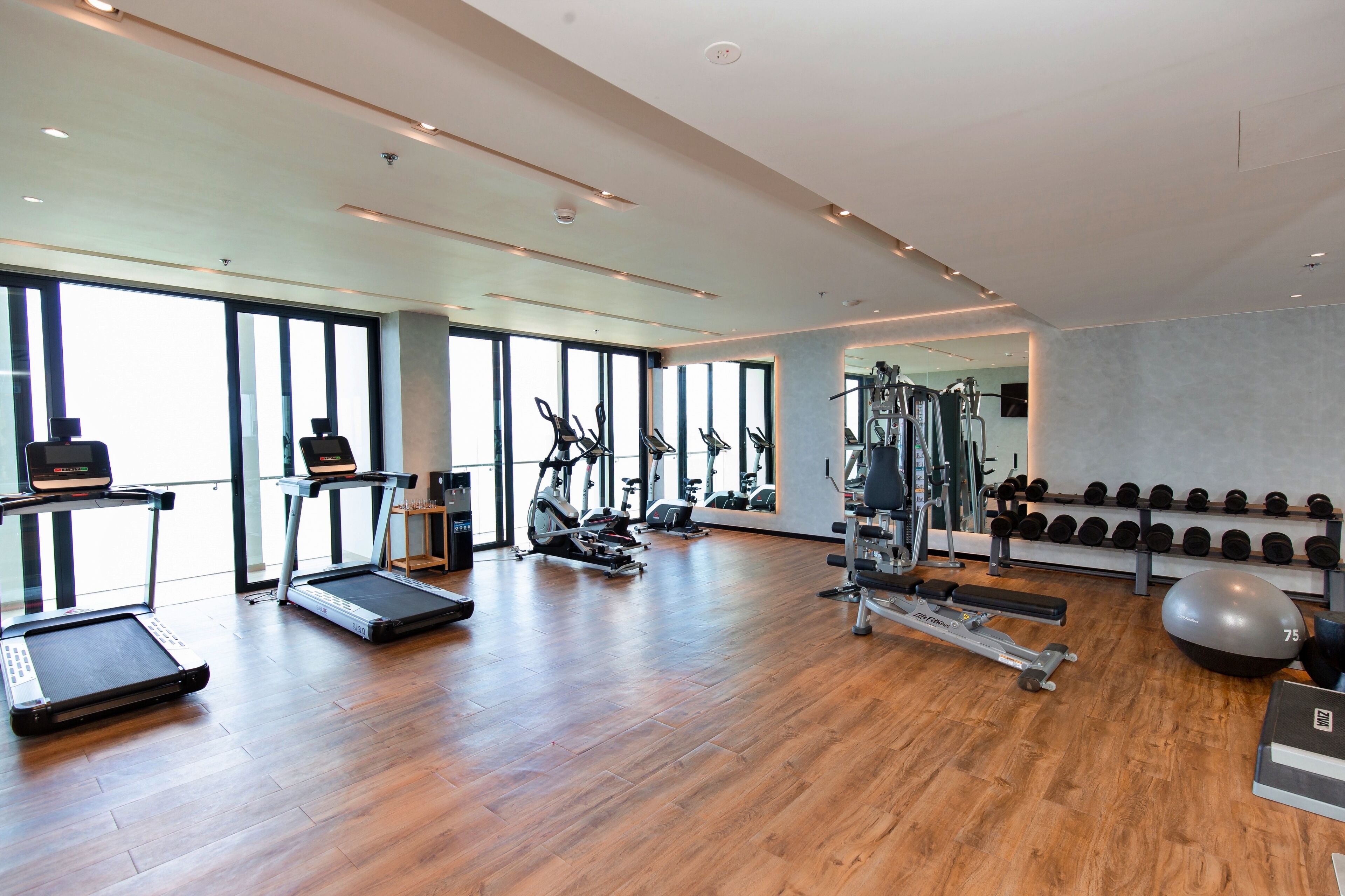 A modern gym with treadmills, stationary bikes, and weight equipment.
