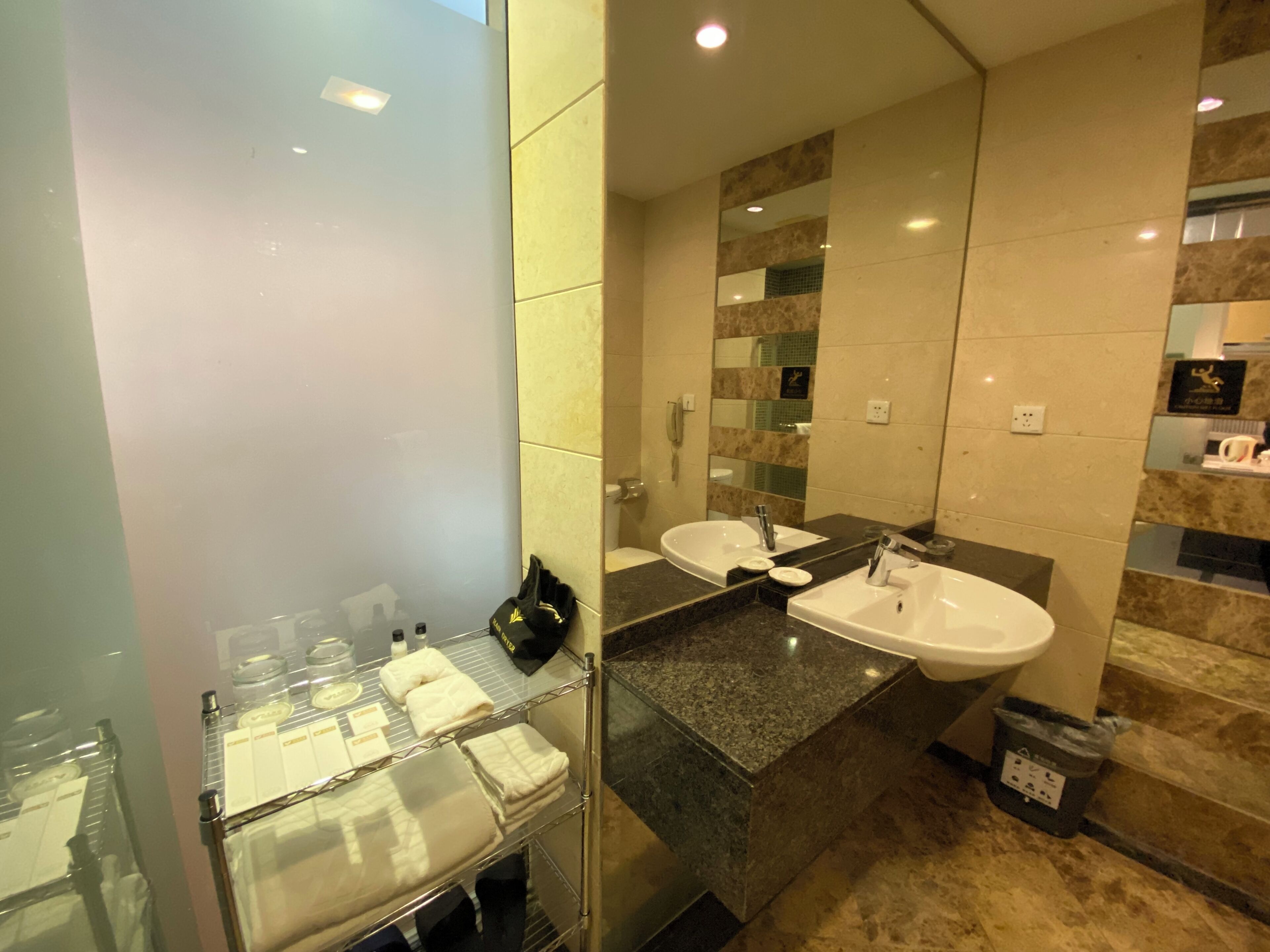 Un bagno moderno con due lavabi, cabina doccia in vetro e porta asciugamani con asciugamani riposti.