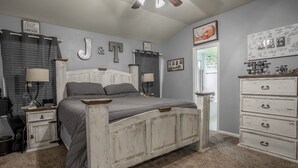 Une chambre à coucher comprenant un lit, des tables de chevet, une commode et des éléments de décoration murale.
