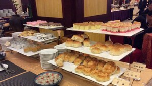 A buffet with various food items and a sign indicating the type of food. - Jiuhuashan Center Hotel (Chizhou)
