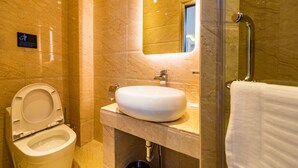 Un baño moderno con inodoro, lavamanos y espejo.