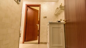 Ein Flur mit einer Holztür, einem weißen Schrank und einer Wandleuchte.