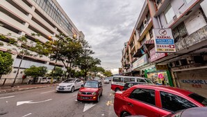 Eine Straße mit Gebäuden, Autos und einem Schild für ein medizinisch-analytisches Labor.