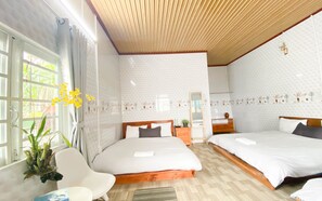 A hotel room with two beds, a wooden ceiling, and a window with curtains. - Homestay Thuy Duong (Da Lat)