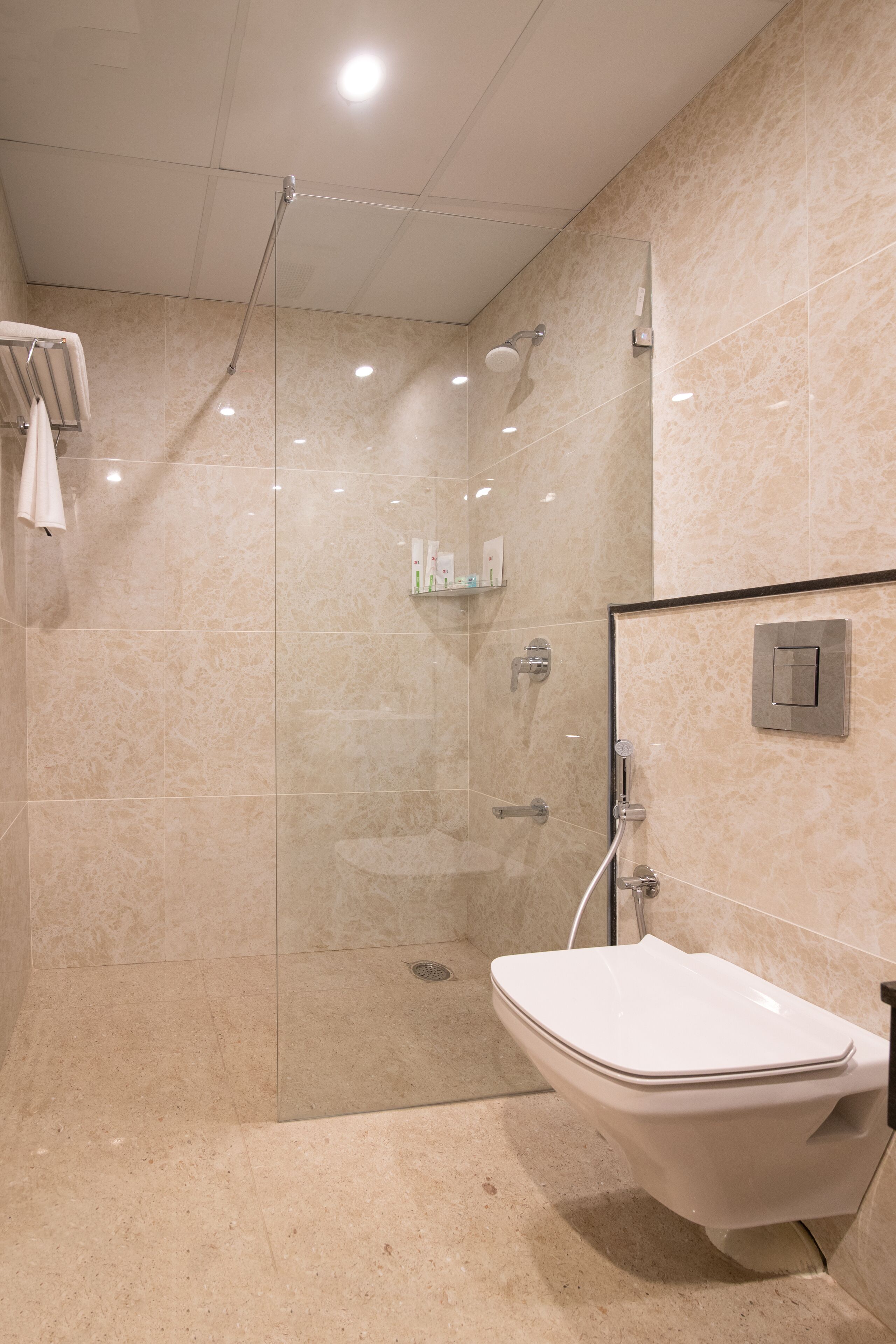 Ein modernes Badezimmer mit einer Duschkabine, einem weißen Waschbecken und einem Handtuchhalter.