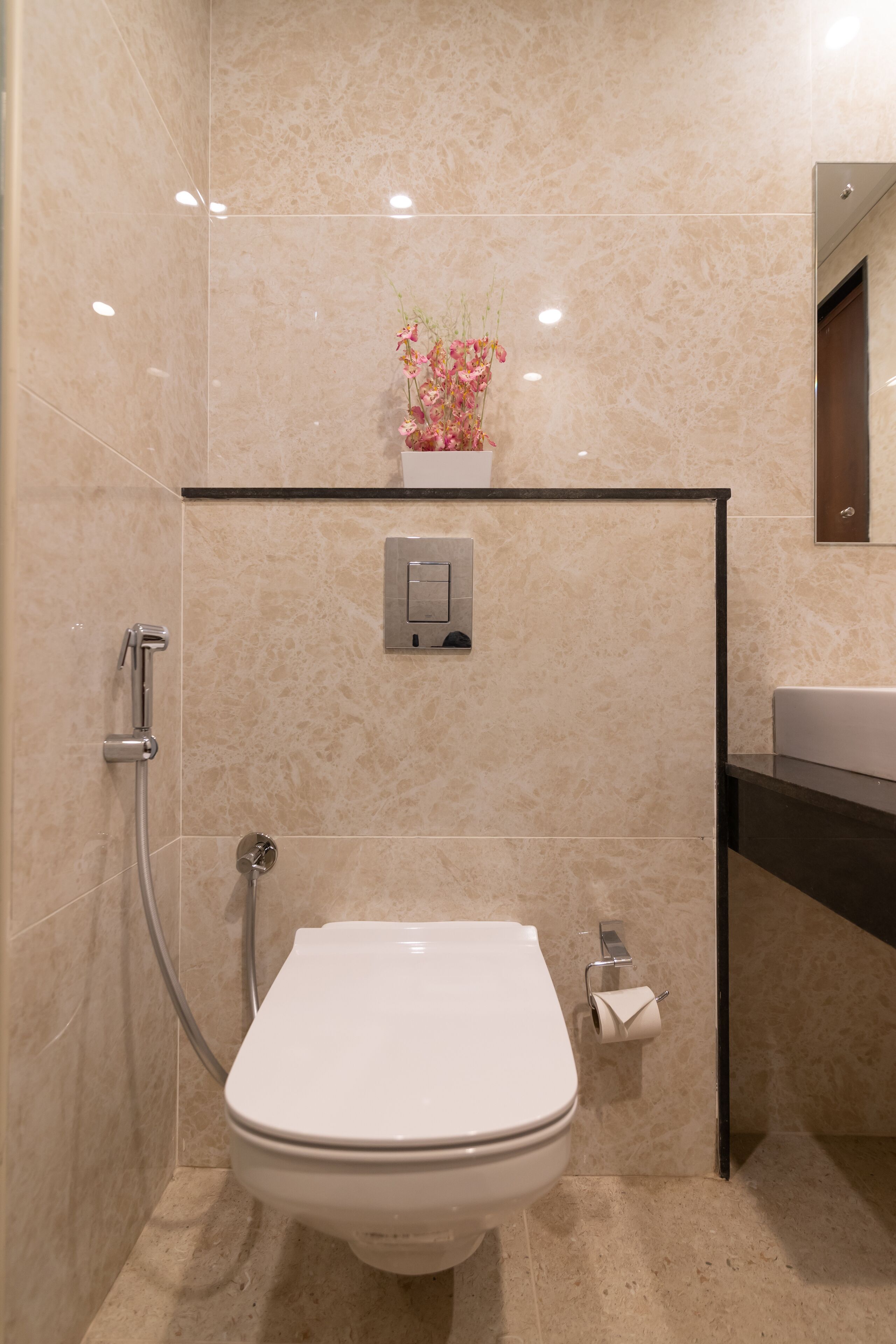 Een moderne badkamer met toilet, douche en wastafel.