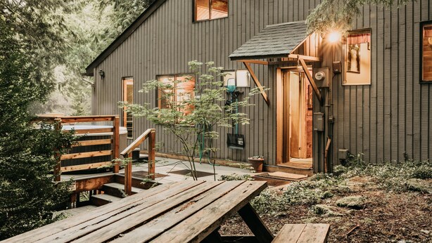 A rustic cabin with a wooden deck, a small garden, and a staircase leading to the entrance. - Mt Baker Lodging - Cabin Story Cabin in the Woods! Free Wifi (Deming)