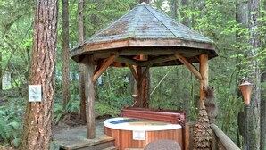 A wooden gazebo with a hot tub in a forested area. - Snowline Cabin #25 A Country-style pet Friendly Cabin With hot tub and Wifi! (Deming)