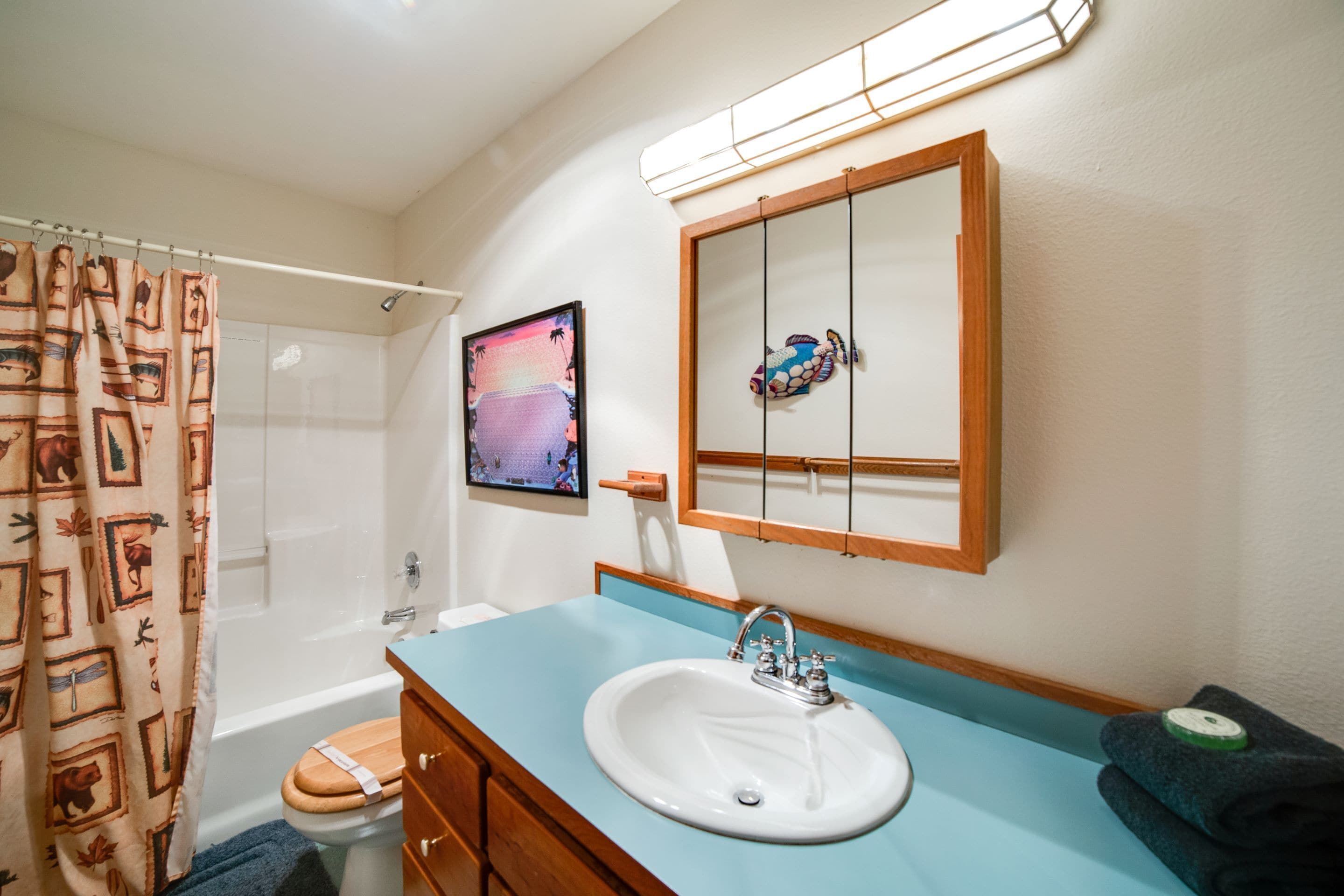 A bathroom with a bathtub, toilet, sink, and a mirror.