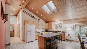 A spacious kitchen with wooden cabinets, a central island, and a large window providing natural light.