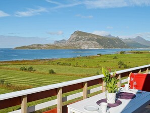 A table with a view of a coastal landscape, including a mountain and the sea. - Holiday Home in Gravdal (Vestvågøy)