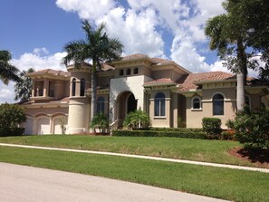 A large, single-story house with a beige facade, multiple windows, and a tiled roof. - Beautiful Huge Marco Island Fl Waterfront Home- Great for Large Families (Marco Island)