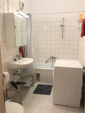 A bathroom with a white sink, mirror, shower, and toilet. - small apartment: close to the subway, quiet courtyard (Rudolfsheim-Fünfhaus)