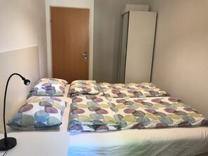 A bedroom with a bed, a desk lamp, a wardrobe, and a door. - small apartment: close to the subway, quiet courtyard (Rudolfsheim-Fünfhaus)