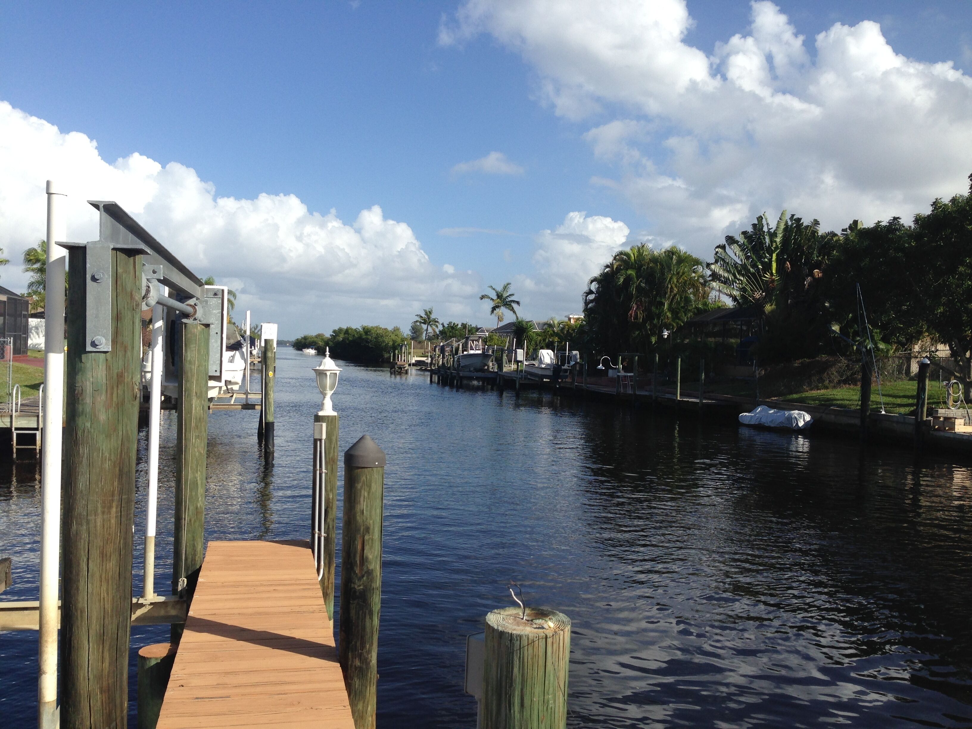 A wooden dock extending into calm water with a clear sky.