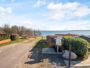 A coastal road leading to a property with a view of the sea.
