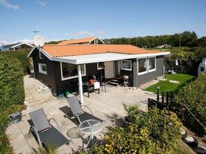 A house with a covered patio, outdoor seating, and a satellite dish. - 4 Star Holiday Home in Juelsminde (Horsens)
