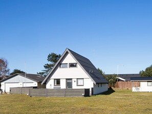 A single-story house with a gabled roof, a front door, and a small porch. - 8 Person Holiday Home in Glesborg (Glesborg)