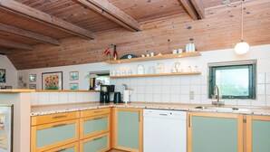Une cuisine avec des meubles en bois, un lave-vaisselle et une fenêtre donnant sur un beau paysage.