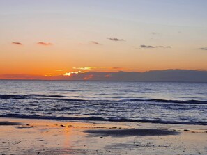 A beach with waves and a sunset. - 10 Person Holiday Home in Albaek (Aalbaek)