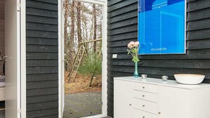 A modern interior with a white cabinet, a blue vase with flowers, and a blue poster on the wall. - 8 Person Holiday Home in Glesborg-by Traum (Glesborg)