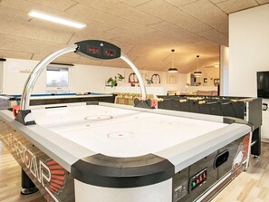 An indoor ice skating rink with a control panel, a seating area, and a television screen. - 4 Star Holiday Home in Brovst (Brovst)