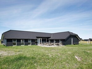 A modern building with a dark roof and large windows.