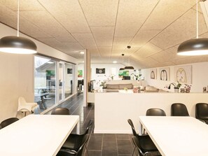 A modern kitchen with a central island, black chairs, and pendant lighting. - 4 Star Holiday Home in Brovst (Brovst)