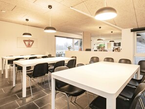 A conference room with white tables and black chairs, a ceiling with recessed lighting, and a window with a view of the outdoors. - 4 Star Holiday Home in Brovst (Brovst)