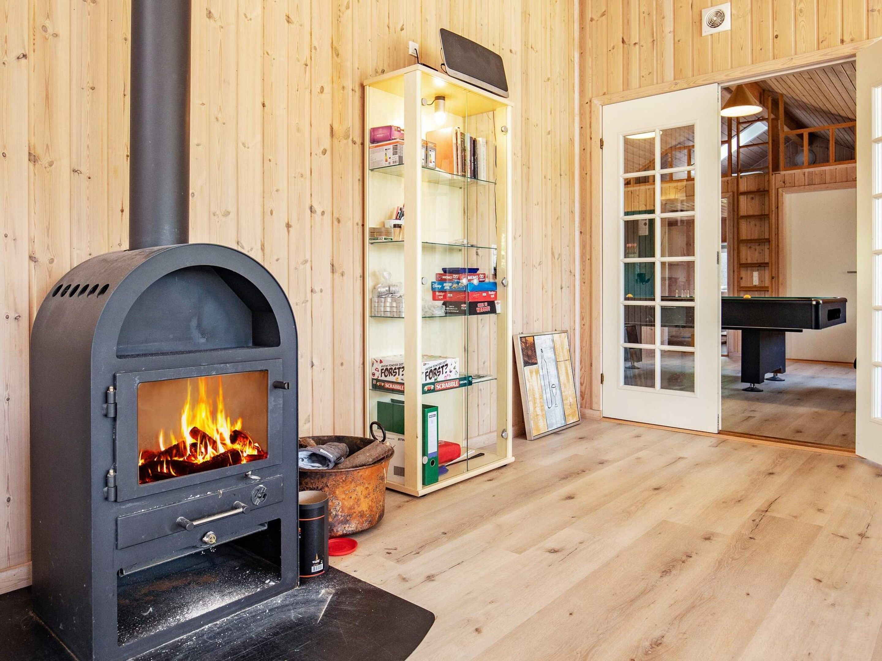 Ein Zimmer mit Kamin, Billardtisch und Bücherregal.