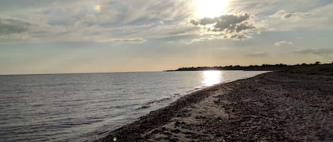A beach with a wide sandy shore and calm water.