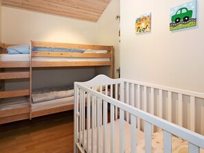 A bunk bed room with a white crib in the foreground. - 5 Star Holiday Home in Hadsund (Hadsund)