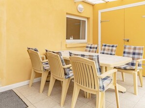 A dining area with a table and chairs, a window, and a door.