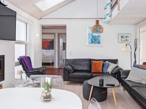 Ein modernes Wohnzimmer mit einer Couch, einem Couchtisch und einem Fernseher.