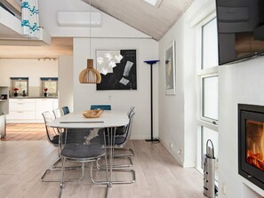Una cocina moderna con comedor, chimenea y obras de arte en las paredes.