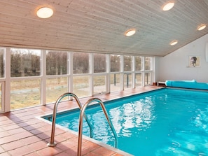An indoor swimming pool with clear glass walls, a tiled floor, and a wooden ceiling. - 4 Star Holiday Home in Ebeltoft (Ebeltoft)