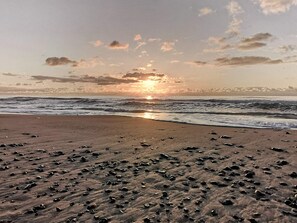 A beach with scattered rocks and waves.