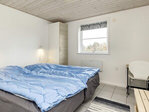 A bedroom with a bed, a window, a chair, and a radiator. - Roomy Holiday Home in Falster near Sea (Vaeggerlose)