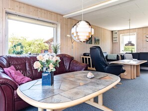 A modern interior with a leather sofa, a round coffee table, a black leather chair, and a wooden dining table. - Spacious Holiday Home in Vinderup near Fjord (Vinderup)