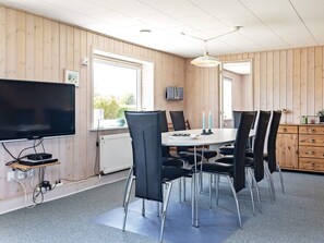 A room with a television, a table with chairs, a window, and a cabinet. - Spacious Holiday Home in Vinderup near Fjord (Vinderup)