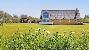 A large house with a sloped roof and a visible garage.