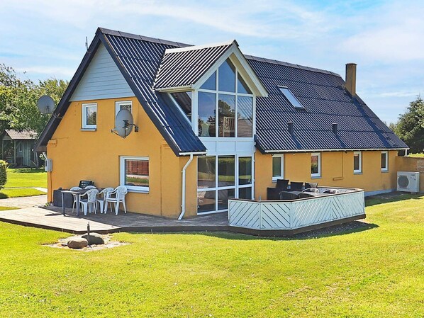 A modern two-story house with a sloped roof, large windows, and a covered outdoor seating area. - Spacious Holiday Home in Vinderup near Fjord (Vinderup)