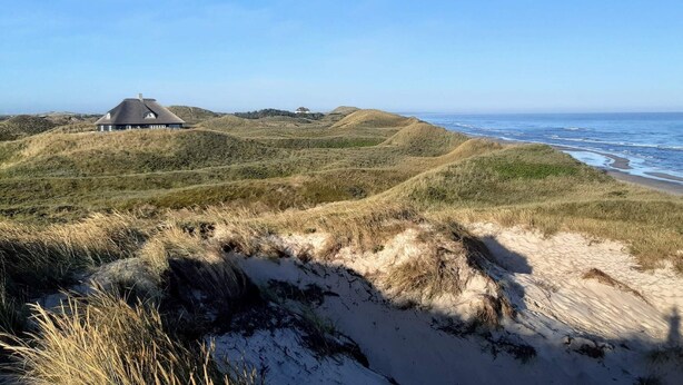 A coastal landscape with dunes, a house, and the ocean. - 4 Star Holiday Home in Albaek (Aalbaek)